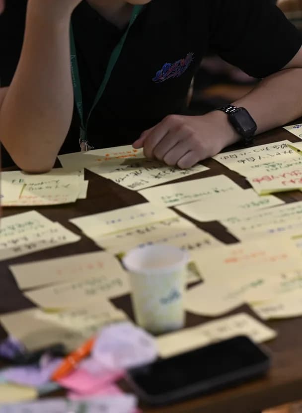 ワークショップで付箋に意見を書き出す参加者の手元