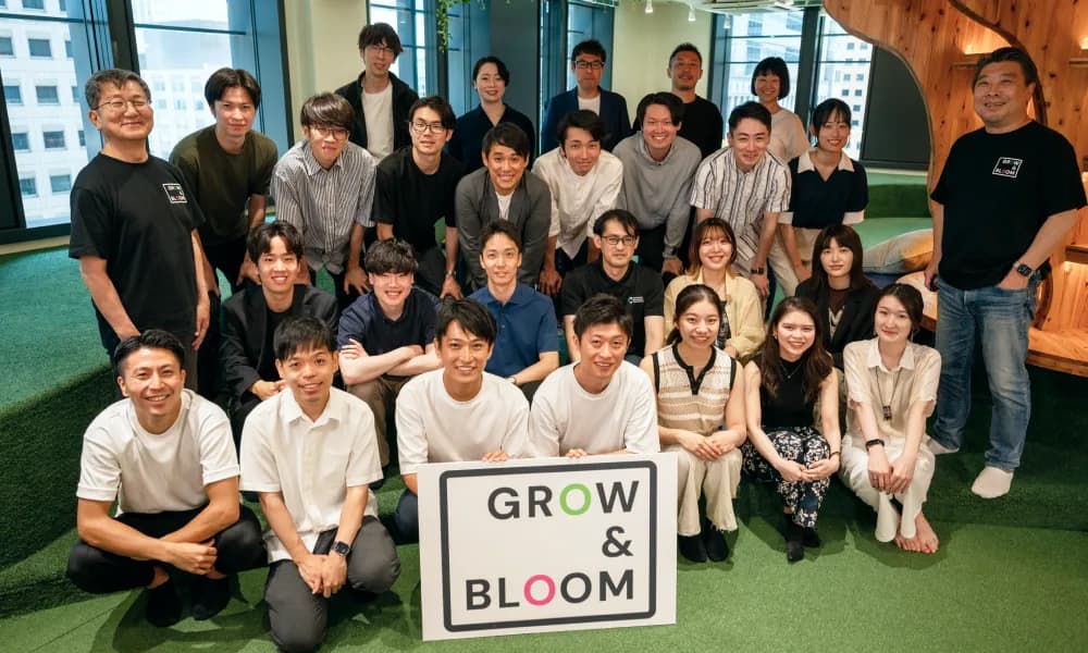 GROW & BLOOM の看板を囲んで並ぶ参加者たちの集合写真